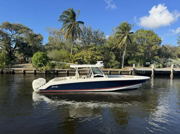  Yacht Photos Pics 2019 Boston Whaler 380 Outrage boat on calm water with palm trees in the background.