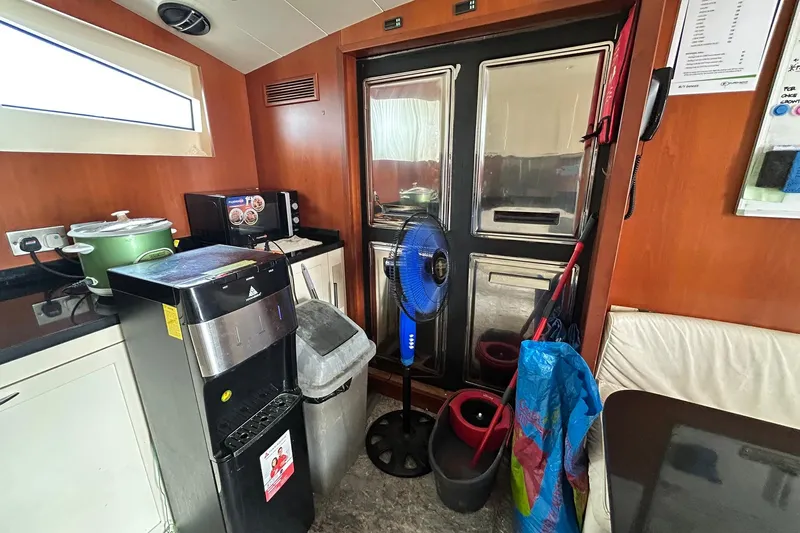 Sunshine Yacht Photos Pics Interior of 2010 Versilcraft Euroyacht Planet 125S Hardtop with kitchen appliances and cleaning tools.