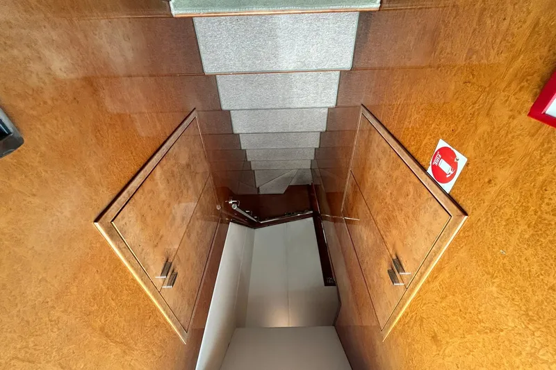 Sunshine Yacht Photos Pics Staircase inside 2010 Versilcraft Euroyacht Planet 125S Hardtop, featuring wooden paneling and carpeted steps.