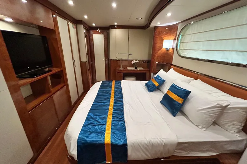 Sunshine Yacht Photos Pics Luxurious bedroom interior of 2010 Versilcraft Euroyacht Planet 125S Hardtop with elegant wood finishes.
