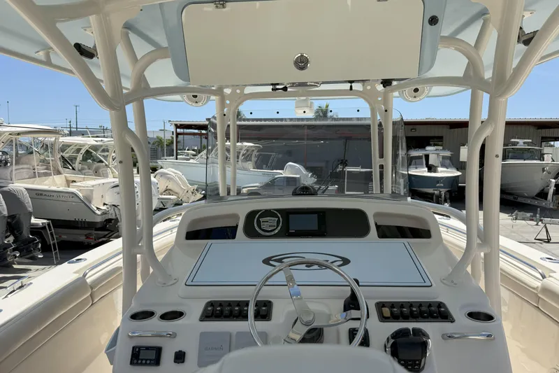 336-311 Brokerage Ron Yacht Photos Pics 2018 Grady-White Canyon 336 boat dashboard with steering wheel and controls in marina setting.