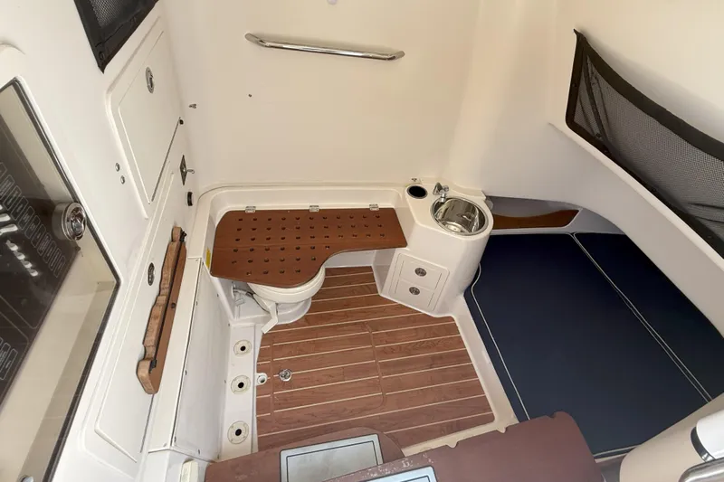336-311 Brokerage Ron Yacht Photos Pics 2018 Grady-White Canyon 336 cabin interior with wood flooring and compact sink.