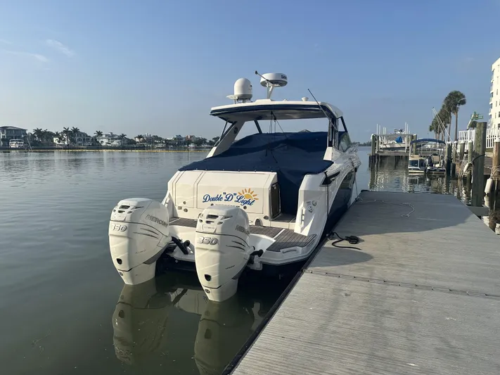  Yacht Photos Pics 2021 Sea Ray Sundancer 320 OB docked by calm waters, featuring twin outboard engines.