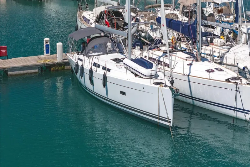  Yacht Photos Pics 2022 Hanse 458 yacht docked in marina, surrounded by clear blue water.
