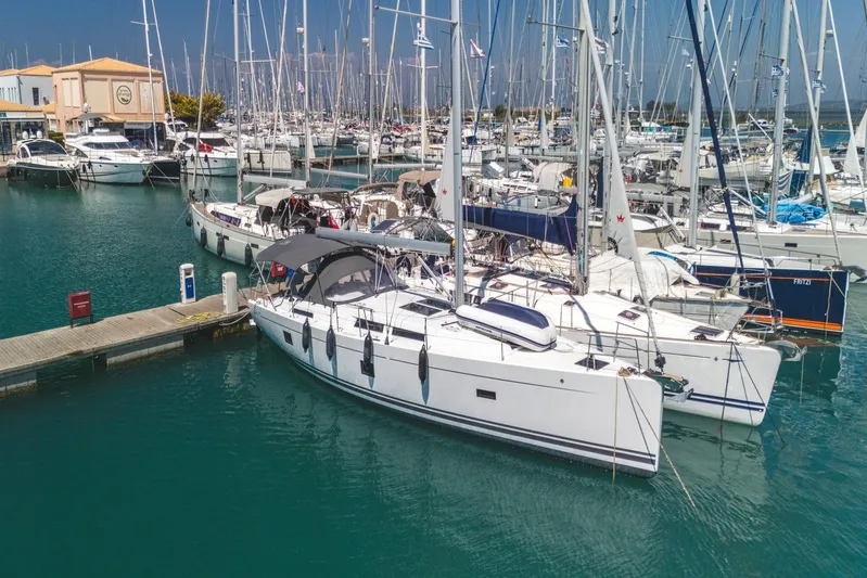  Yacht Photos Pics 2022 Hanse 458 yacht docked in a marina with other sailboats.