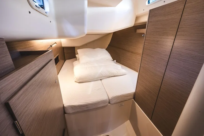  Yacht Photos Pics Interior cabin of 2022 Hanse 458 yacht with cozy bed and wooden finish.