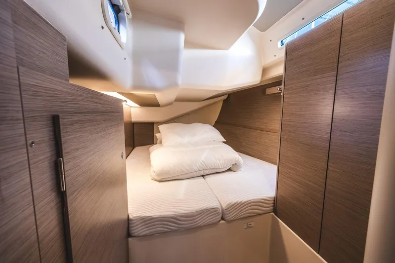  Yacht Photos Pics Luxurious cabin interior of 2022 Hanse 458 yacht with cozy bedding and wooden finish.