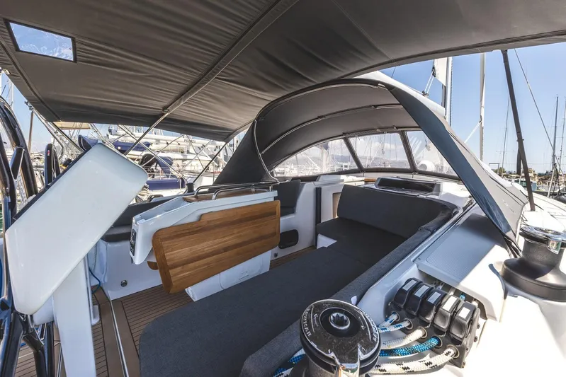  Yacht Photos Pics 2022 Hanse 458 yacht cockpit with modern seating and canopy, docked at marina.