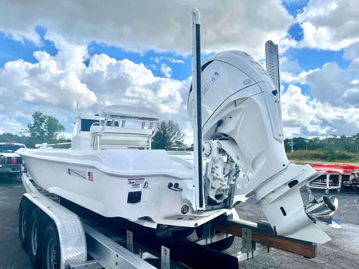  Yacht Photos Pics 2025 Contender 26 Bay boat on trailer, featuring powerful outboard motor under cloudy sky.