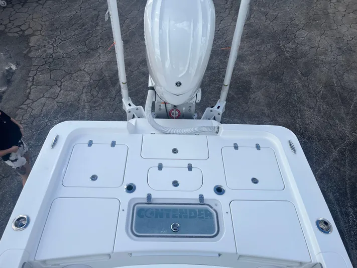  Yacht Photos Pics 2025 Contender 26 Bay boat deck with storage compartments and motor, viewed from above.