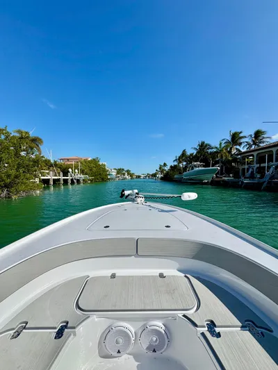  Yacht Photos Pics 2025 Contender 26 Bay boat cruising on a clear, sunny waterway.