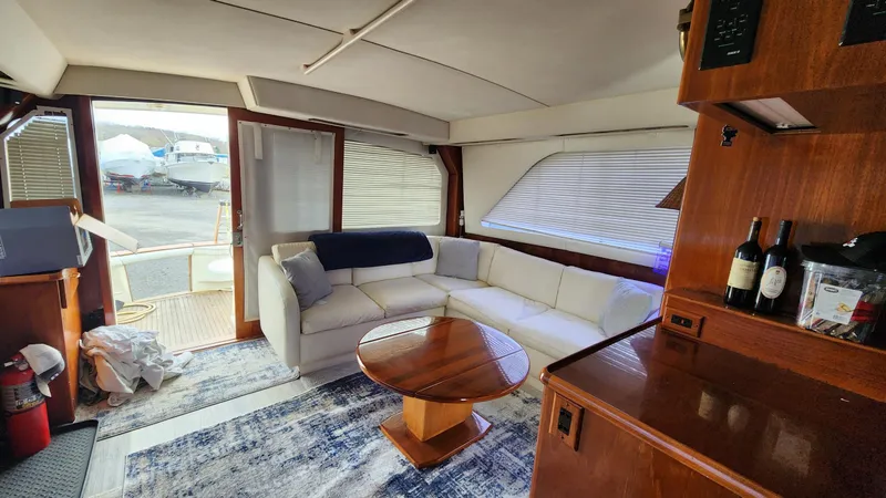 Reel Easy Yacht Photos Pics Luxurious interior of 1989 Ocean Yachts 55 with white sofa and wooden accents.