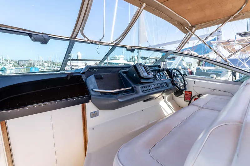 Sea Oddity Yacht Photos Pics 1991 Sea Ray 330 Sundancer helm with beige seating and marina view.