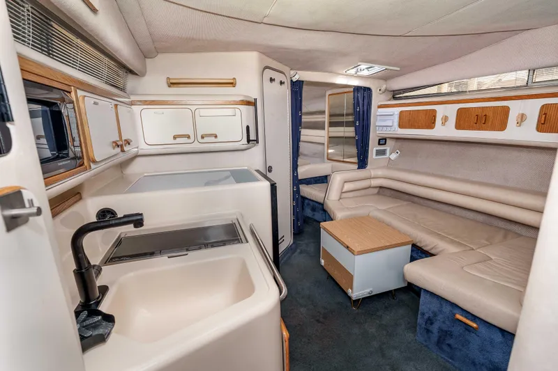 Sea Oddity Yacht Photos Pics 1991 Sea Ray 330 Sundancer interior with kitchenette, seating, and storage cabinets.