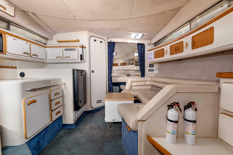 Sea Oddity Yacht Photos Pics Interior of a 1991 Sea Ray 330 Sundancer yacht with seating, cabinets, and fire extinguishers.