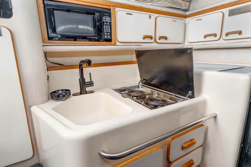 Sea Oddity Yacht Photos Pics 1991 Sea Ray 330 Sundancer kitchen with sink, stove, and microwave.