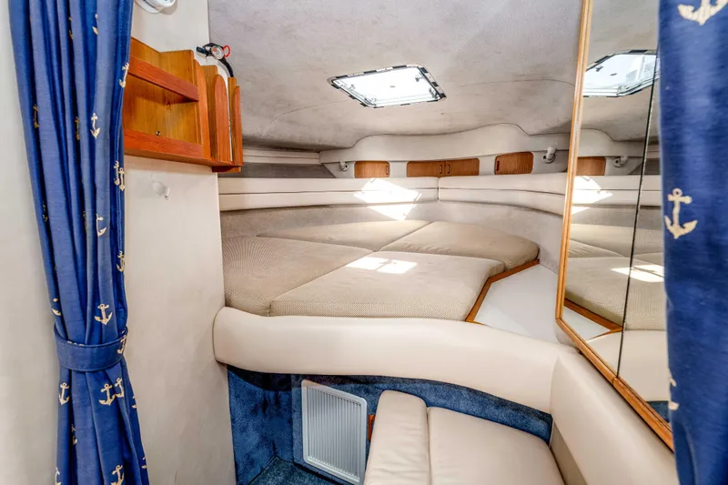 Sea Oddity Yacht Photos Pics Interior cabin of 1991 Sea Ray 330 Sundancer with cozy bed and nautical decor.