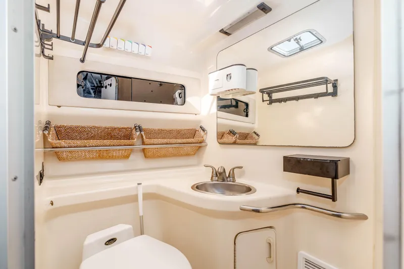 Sea Oddity Yacht Photos Pics 1991 Sea Ray 330 Sundancer bathroom with sink, mirror, and storage baskets.