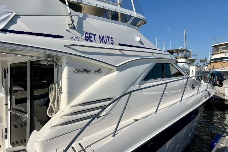 Get Nuts Yacht Photos Pics 2000 Sea Ray 400 Sedan Bridge yacht docked at marina, side view.