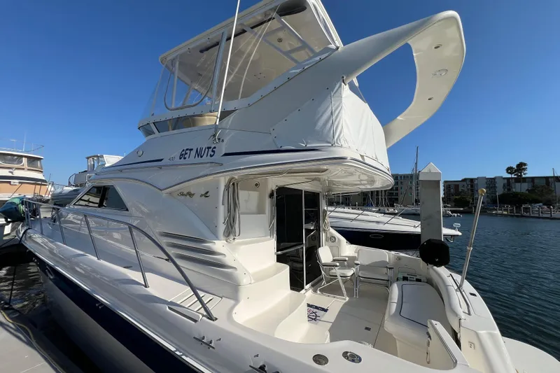 Get Nuts Yacht Photos Pics 2000 Sea Ray 400 Sedan Bridge yacht docked at marina under clear blue sky.