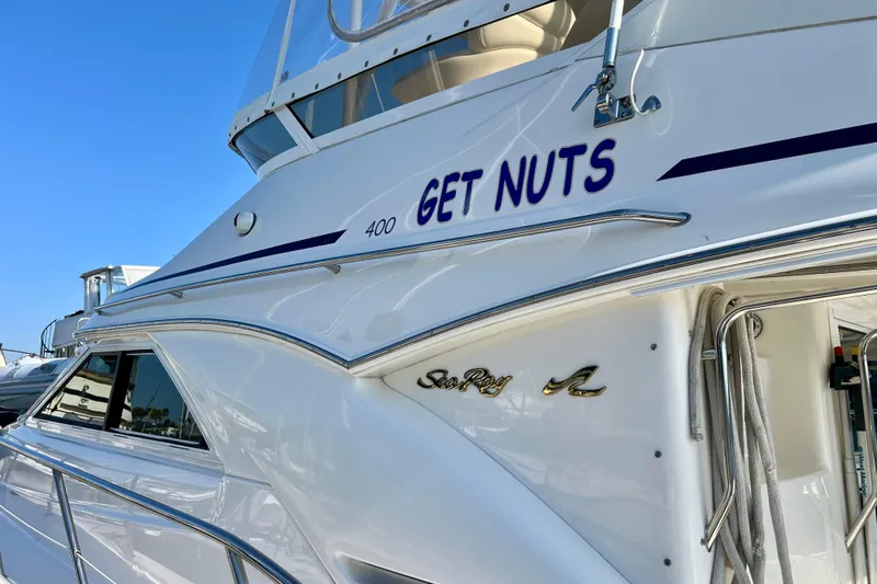 Get Nuts Yacht Photos Pics Sea Ray 400 Sedan Bridge 2000 yacht with "Get Nuts" name, docked under clear blue sky.