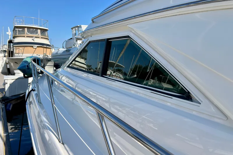 Get Nuts Yacht Photos Pics 2000 Sea Ray 400 Sedan Bridge yacht docked, showcasing sleek design and reflective windows.