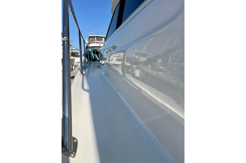 Get Nuts Yacht Photos Pics Side view of a 2000 Sea Ray 400 Sedan Bridge yacht, showcasing sleek design and railing.
