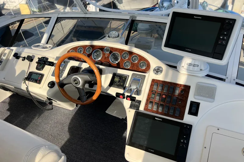 Get Nuts Yacht Photos Pics Cockpit of 2000 Sea Ray 400 Sedan Bridge with navigation equipment and wooden steering wheel.