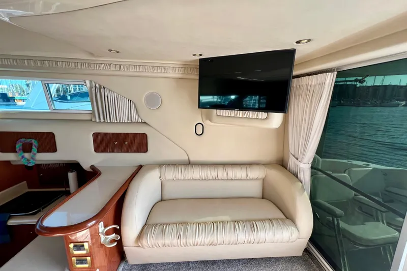 Get Nuts Yacht Photos Pics Interior of 2000 Sea Ray 400 Sedan Bridge with sofa, TV, and window view.