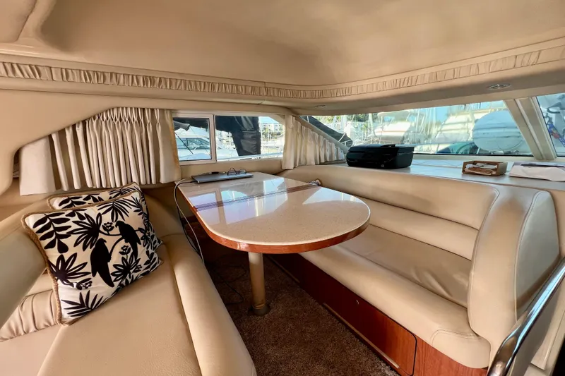 Get Nuts Yacht Photos Pics Luxurious interior of 2000 Sea Ray 400 Sedan Bridge with elegant seating and table.