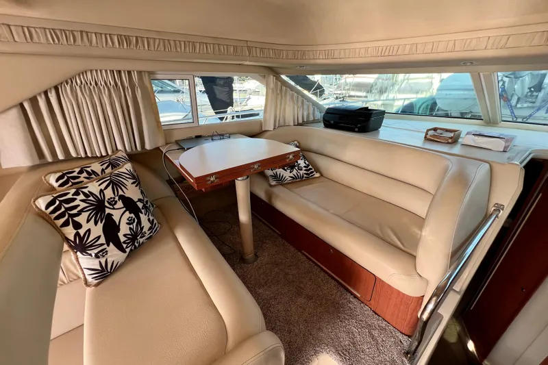 Get Nuts Yacht Photos Pics Luxurious interior of 2000 Sea Ray 400 Sedan Bridge with beige seating and floral cushions.