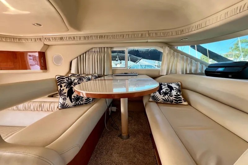 Get Nuts Yacht Photos Pics Luxurious interior of 2000 Sea Ray 400 Sedan Bridge yacht with elegant seating and table.