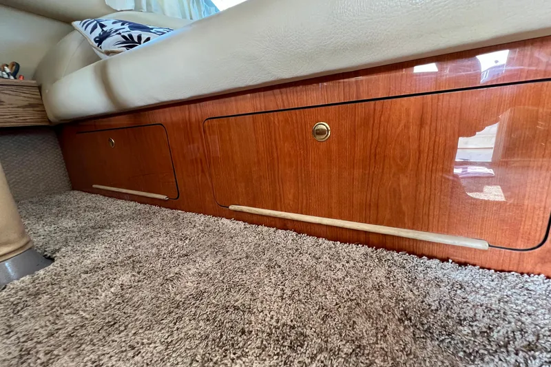 Get Nuts Yacht Photos Pics Interior view of 2000 Sea Ray 400 Sedan Bridge with wood cabinetry and carpet flooring.