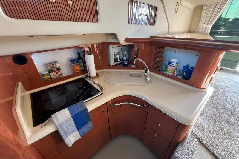 Get Nuts Yacht Photos Pics 2000 Sea Ray 400 Sedan Bridge kitchen with stove, sink, and storage cabinets.