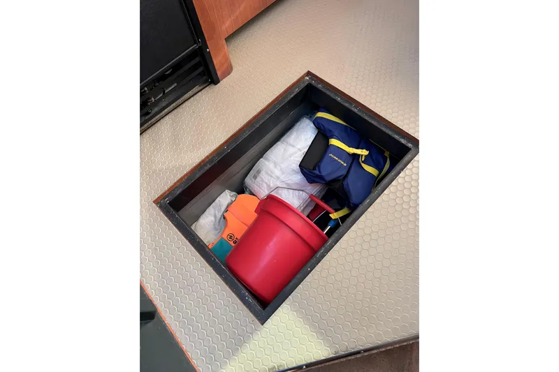 Get Nuts Yacht Photos Pics Storage compartment on 2000 Sea Ray 400 Sedan Bridge with life jacket and red bucket.