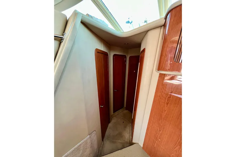 Get Nuts Yacht Photos Pics Interior hallway of 2000 Sea Ray 400 Sedan Bridge with wooden doors and carpeted floor.
