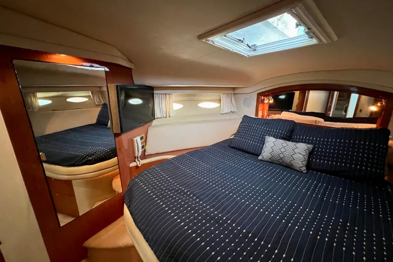 Get Nuts Yacht Photos Pics Luxurious bedroom interior of 2000 Sea Ray 400 Sedan Bridge yacht with skylight and TV.