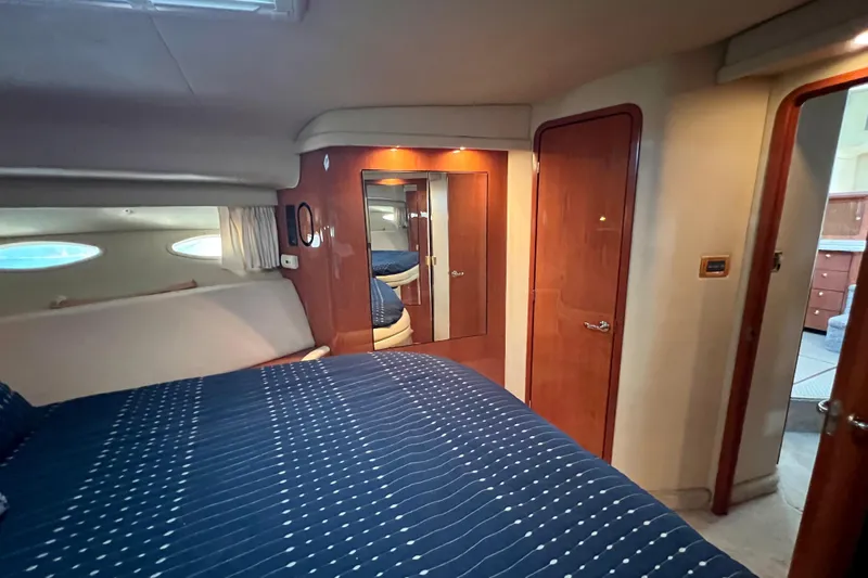 Get Nuts Yacht Photos Pics Interior of 2000 Sea Ray 400 Sedan Bridge yacht, featuring cozy bedroom with blue bedding.