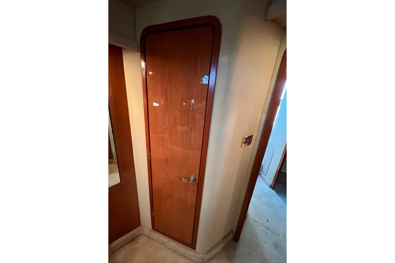 Get Nuts Yacht Photos Pics Interior view of 2000 Sea Ray 400 Sedan Bridge, featuring a wooden door and carpeted floor.