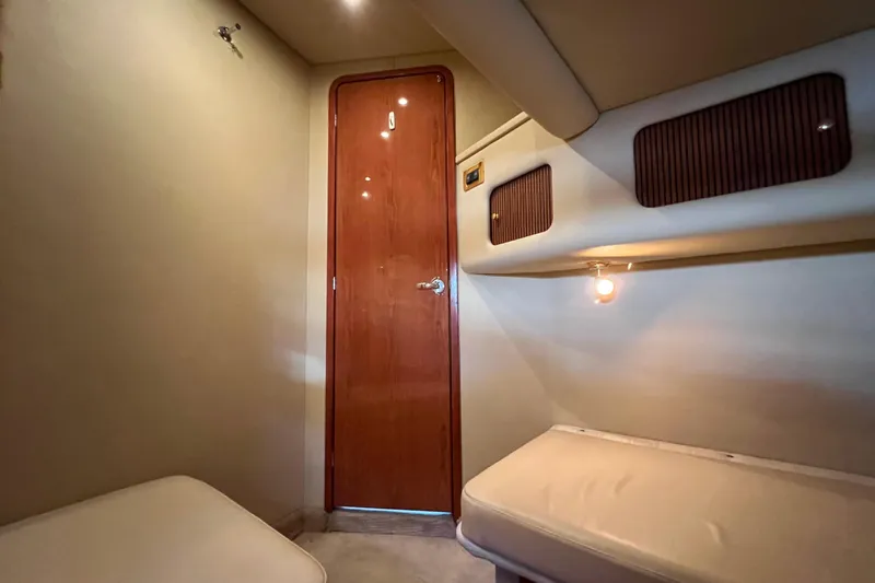 Get Nuts Yacht Photos Pics Interior cabin of 2000 Sea Ray 400 Sedan Bridge yacht, featuring wooden door and cozy seating.