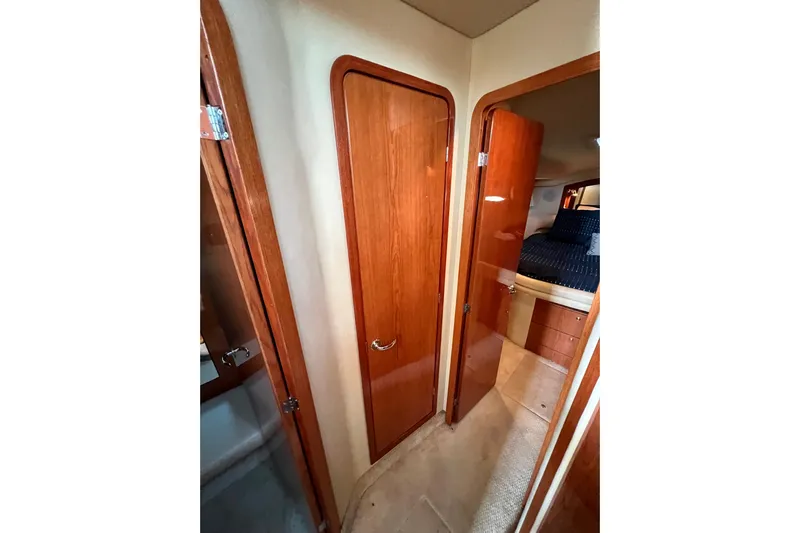 Get Nuts Yacht Photos Pics Interior view of 2000 Sea Ray 400 Sedan Bridge, featuring wooden doors and cozy bedroom.