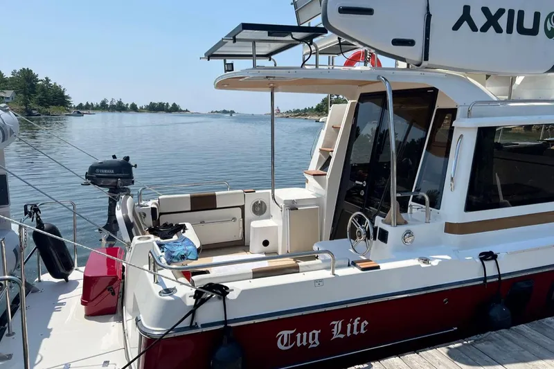 Tug Life Yacht Photos Pics 2017 Ranger Tugs R-29 CB boat docked by serene lake with lush greenery.