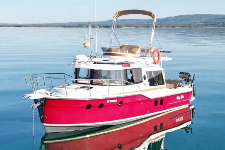 Tug Life Yacht Photos Pics 2017 Ranger Tugs R-29 CB boat on calm water, featuring a vibrant red hull.