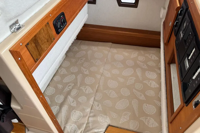 Tug Life Yacht Photos Pics 2017 Ranger Tugs R-29 CB interior cabin with patterned flooring and wooden accents.
