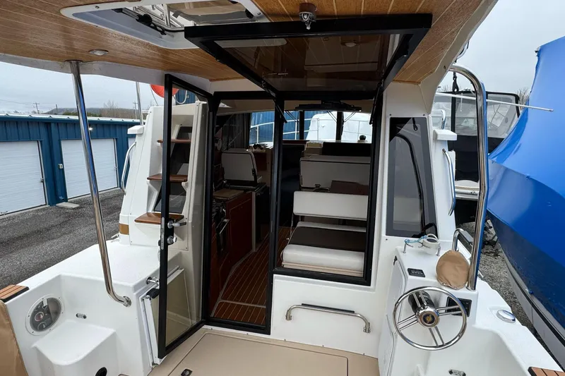 Tug Life Yacht Photos Pics 2017 Ranger Tugs R-29 CB boat interior with seating and helm, docked outdoors.