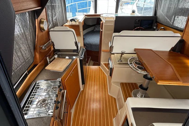Tug Life Yacht Photos Pics Interior of 2017 Ranger Tugs R-29 CB, featuring kitchen, seating, and sleeping area.