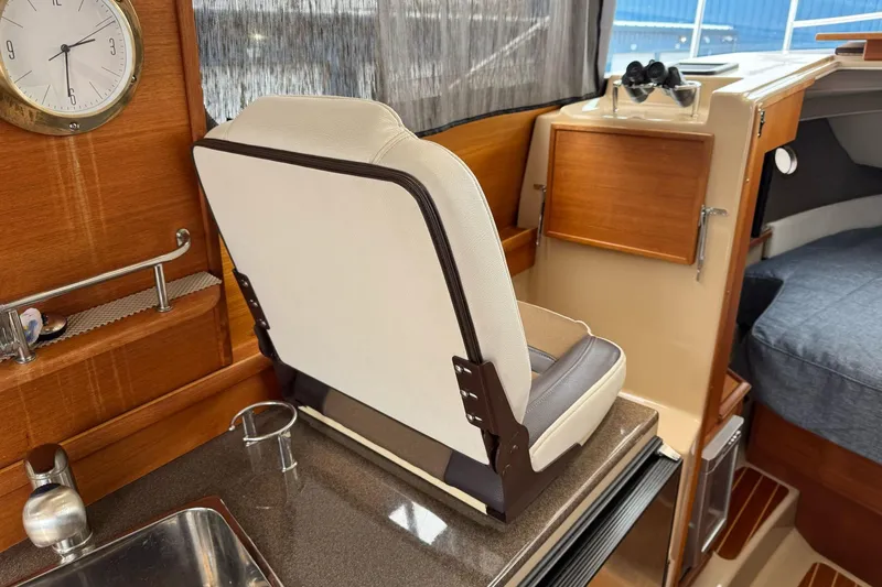 Tug Life Yacht Photos Pics Interior of 2017 Ranger Tugs R-29 CB, featuring helm seat and wooden cabinetry.