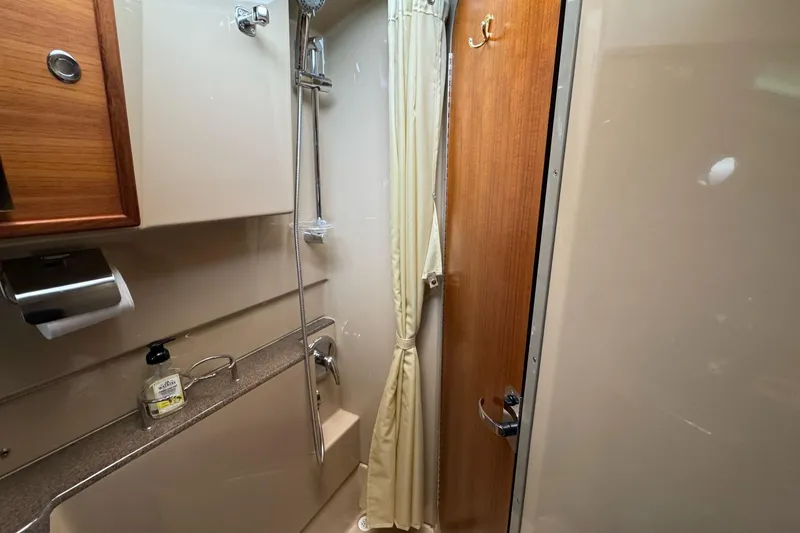 Tug Life Yacht Photos Pics 2017 Ranger Tugs R-29 CB bathroom with shower, curtain, and wooden door.