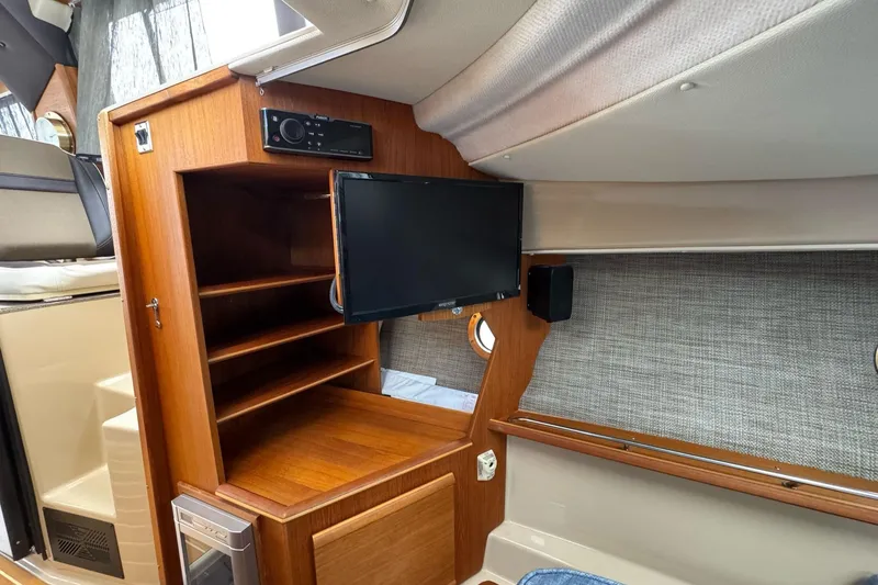 Tug Life Yacht Photos Pics 2017 Ranger Tugs R-29 CB interior with wooden cabinetry and mounted TV.