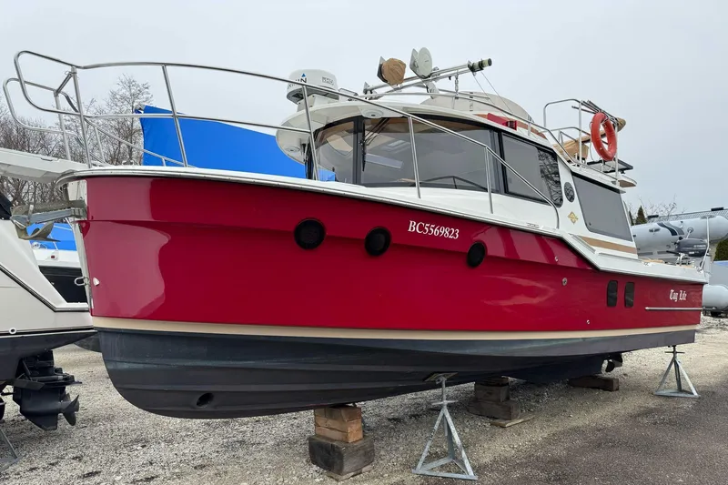 Tug Life Yacht Photos Pics 2017 Ranger Tugs R-29 CB boat in red, displayed on stands in a boatyard.